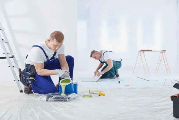 Painter applying a fresh coat of interior paint in a modern home